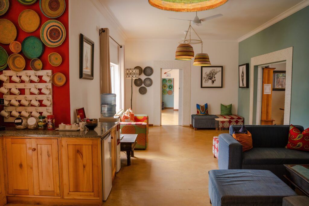 Colorful living room with woven baskets on a red wall and a wooden kitchen counter on the left.